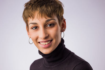 Close-up portrait of young woman against white background