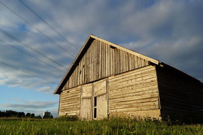 Abandoned barn on field against sky