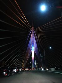 Illuminated bridge against sky at night