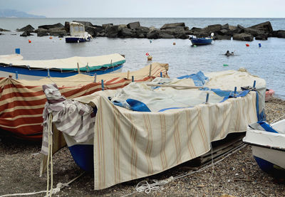 Boats moored on beach against sky