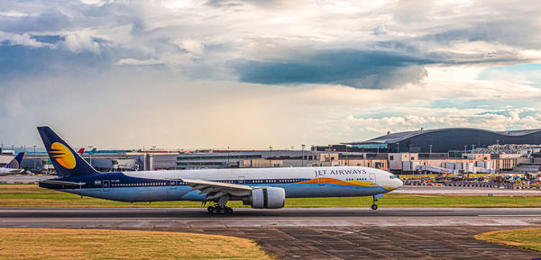 Airplane on runway against sky