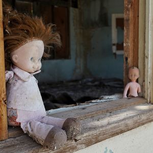 Doll on windowsill in abandoned building