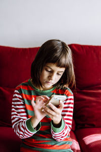 Portrait of a beautiful young woman sitting on sofa at home
