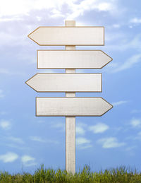 Low angle view of cross on field against sky