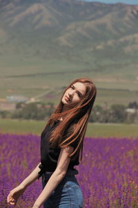 Woman standing on purple flower on field