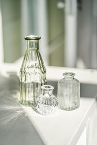 Three glass vases on the table in the interior of the house.