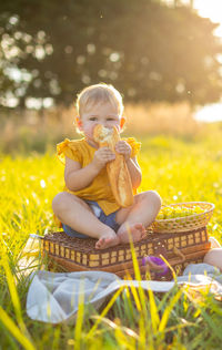 Full length of girl sitting on wicker basket