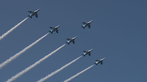 Low angle view of airplane flying against clear blue sky