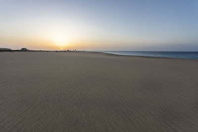 Scenic view of beach against sky during sunset