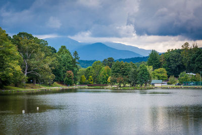 Scenic view of lake by trees against sky