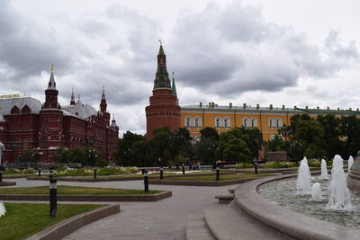 Buildings in city against cloudy sky