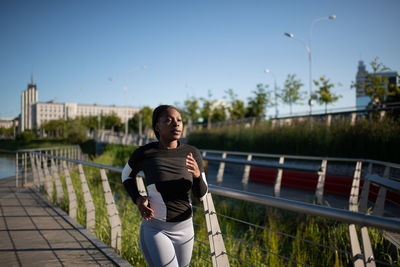 African american sportswoman running on embankment