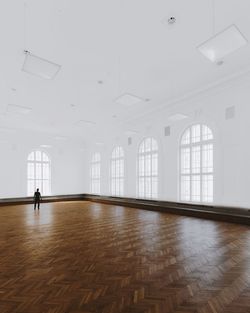 Rear view of man standing on hardwood floor