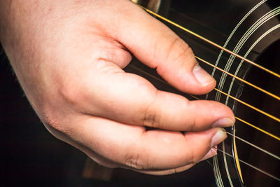 Cropped image of hand playing guitar