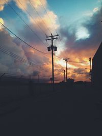 Silhouette of electricity pylon at sunset