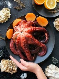 Freshly cooked octopus is lying on a black plate