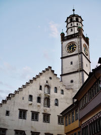 Low angle view of clock tower amidst buildings against sky