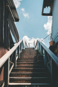 Low angle view of staircase amidst buildings against sky