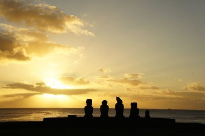 Silhouette of people on beach at sunset