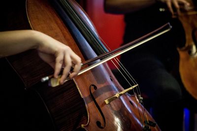 Cropped hand of cellist playing cello on stage