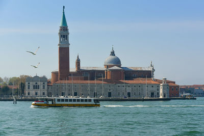 Canal by church of san giorgio maggiore against sky