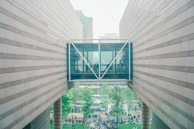 Modern bridge by buildings against sky in city