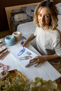 Portrait of smiling young woman sitting on table