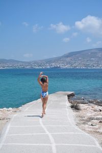 Rear view of man on beach against sky