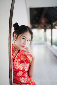 Portrait of woman in traditional clothing standing against wall