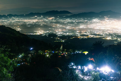 High angle view of illuminated cityscape against sky at night