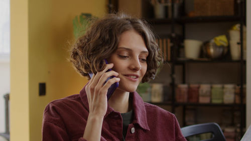 Young woman using mobile phone at home