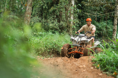 Side view of man standing in forest