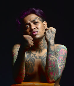 Portrait of man against black background