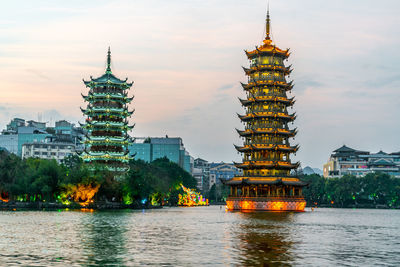 Illuminated buildings in city against sky