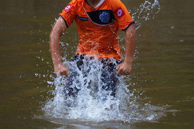 Boy splashing water in lake