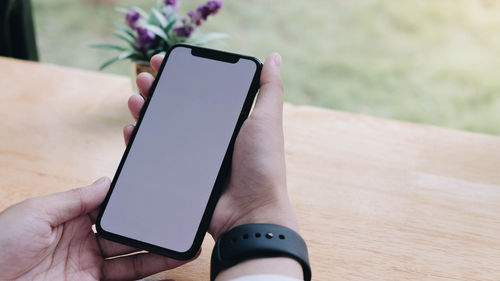 Midsection of person using mobile phone on table