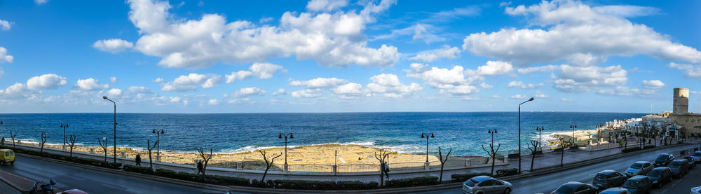 Boats in sea against cloudy sky