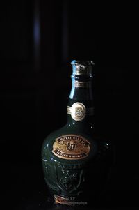 Close-up of glass bottle against black background