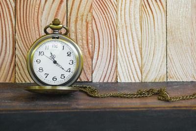 Close-up of antique pocket watch on wooden table