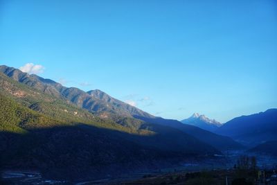 Scenic view of mountains against blue sky