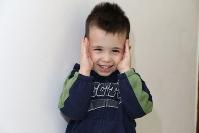 Portrait of smiling boy against wall