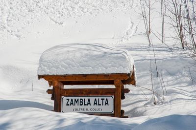 Text on snow covered field against snowcapped mountain