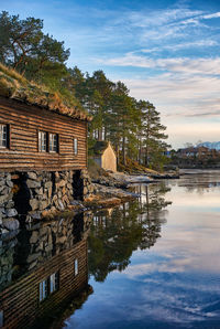 Buildings by lake against sky