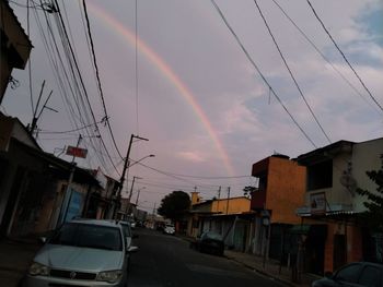 Rainbow over buildings in city against sky