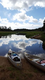 Boats moored on lake against sky