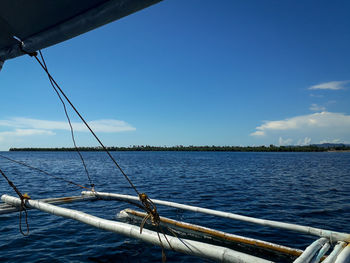 Boat sailing on river against clear blue sky