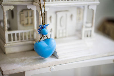 Close-up of blue heart shape hanging on model home