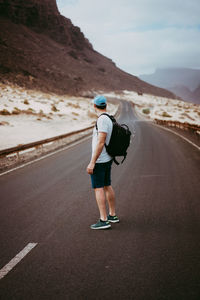 Rear view of woman with umbrella on road