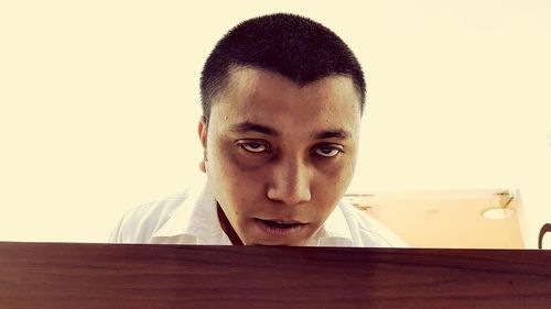 Close-up portrait of young man against white background