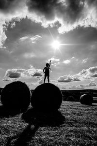 Silhouette man standing on field against sky during sunset